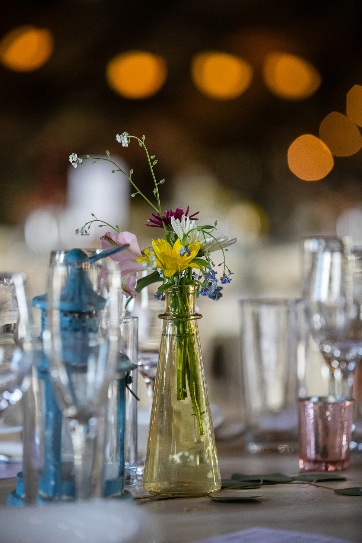A close-up of a beautiful floral arrangement on a table at a wedding reception at Blenheim Hill Farm
