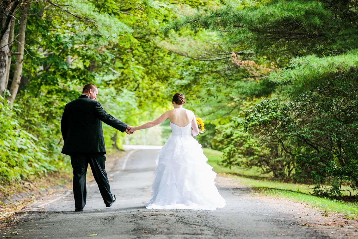 a bride and groom taking a stroll hand in hand at The Interlaken Inn