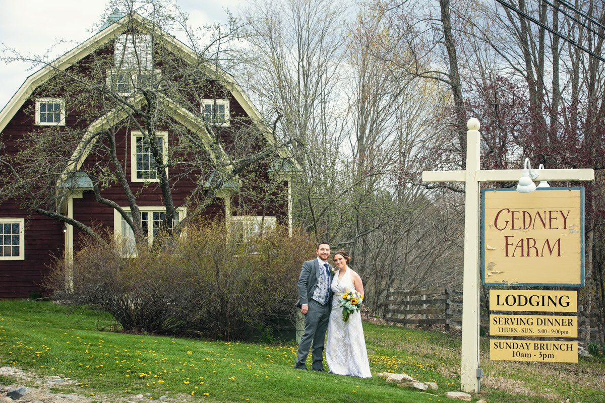 The bride and groom in front of the sign at Gedney farm in the Berkshires