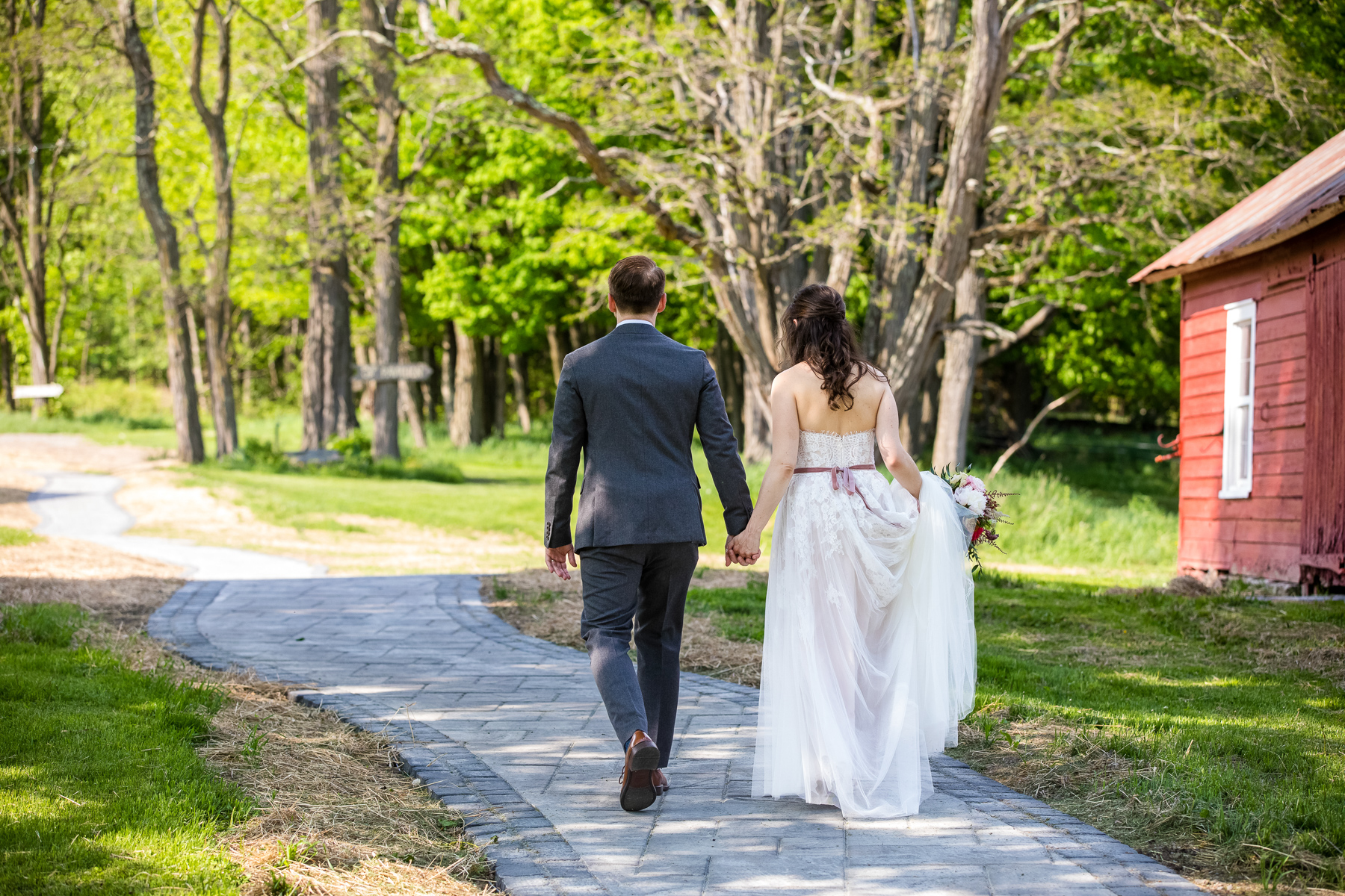 The bride and groom taking a walk on the property at Blenheim Hill Farm, holding hands and looking happy