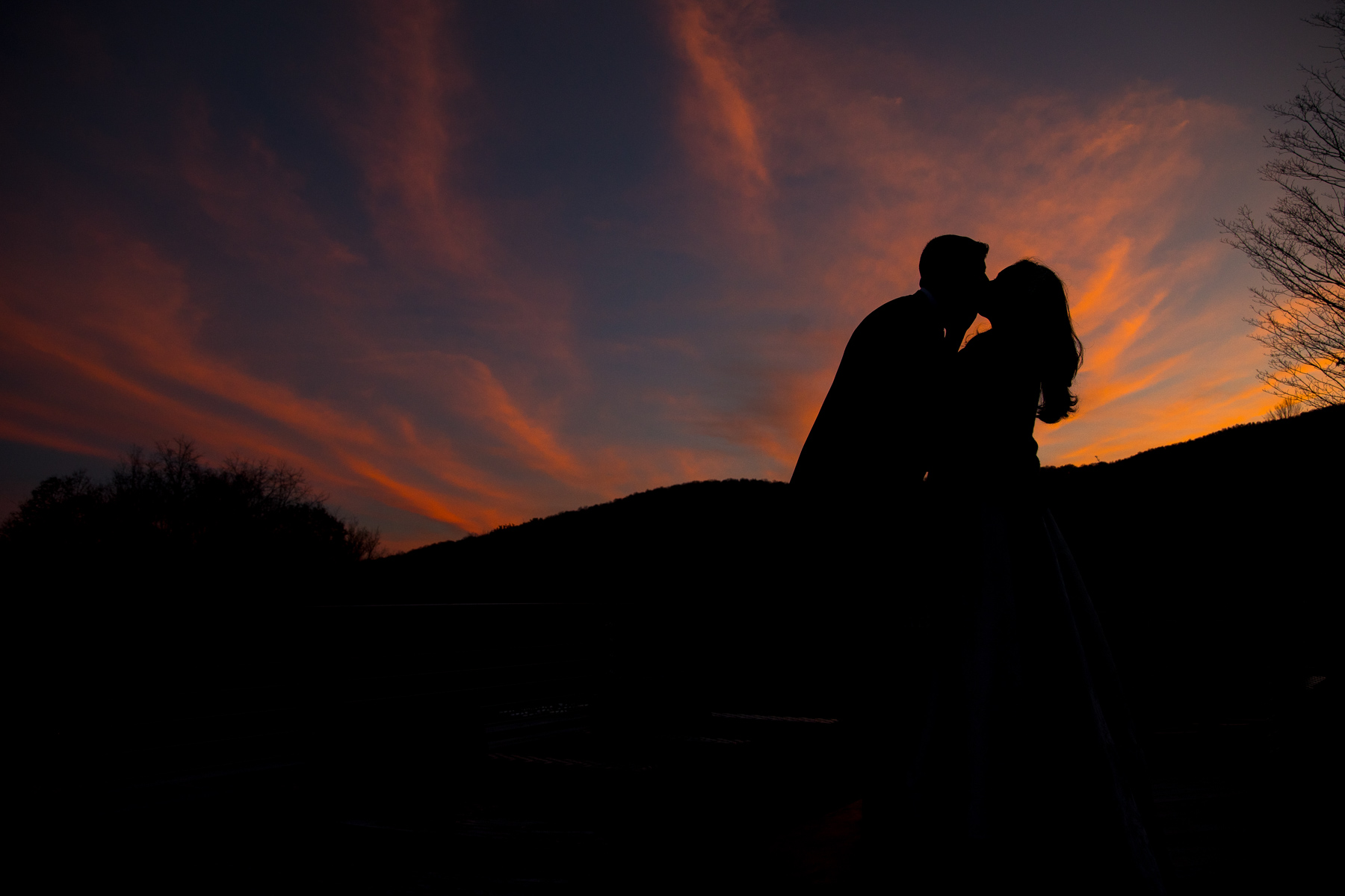 bride and groom kissing with a beautiful sunset