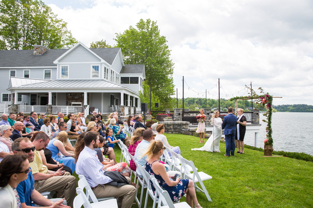 A couple exchange vows in front of the stunning Pontoosuc Lake at the Lake House Guest Cottages of the Berkshires.