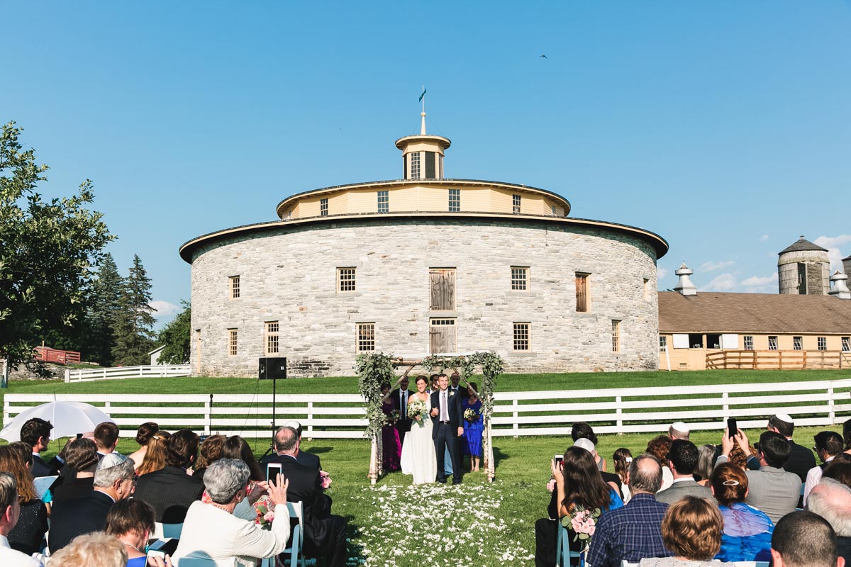 wedding ceremony in front of the round stone barn at Hancock Shaker VCillage