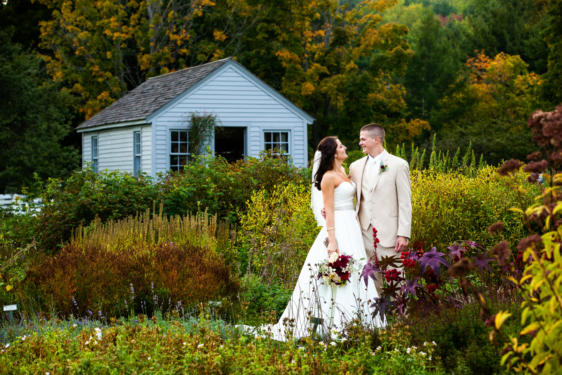 The bride and groom in front of a vibrant and colorful flower garden