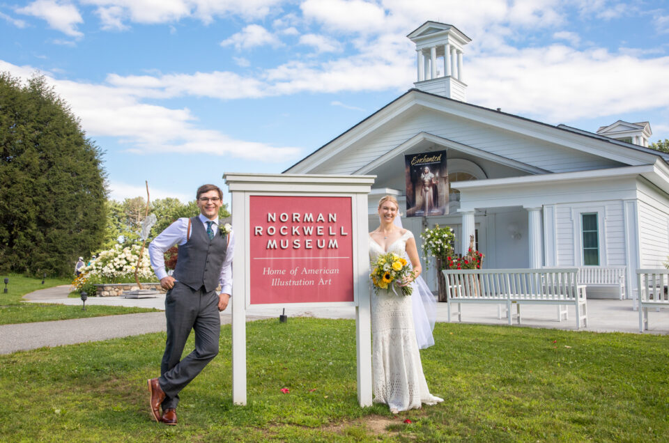A bride and groom in front of the Norman Rockwell Museum in the Berkshires
