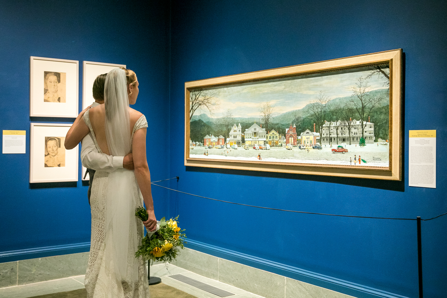 a wedding couple looking at the art at the Norman Rockwell Museum