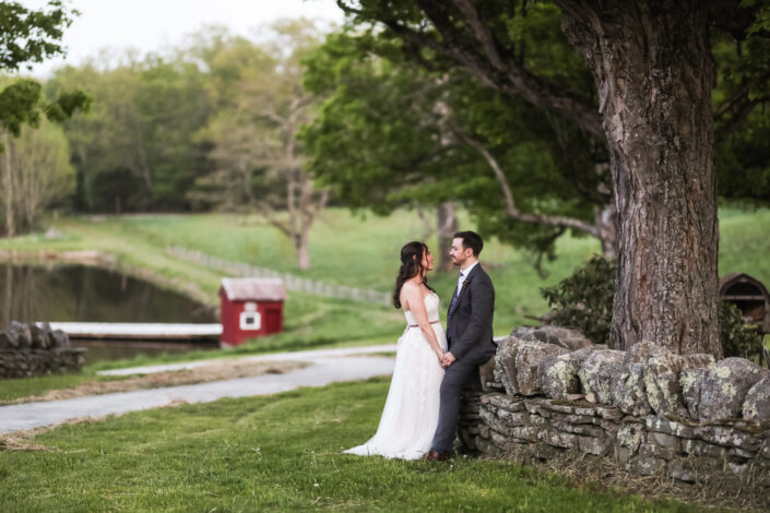 bride and groom against a stone wall at Blenheim Hill Farm