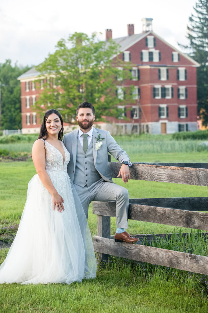 a bride and groom on the fence at Hancock Shaker Village